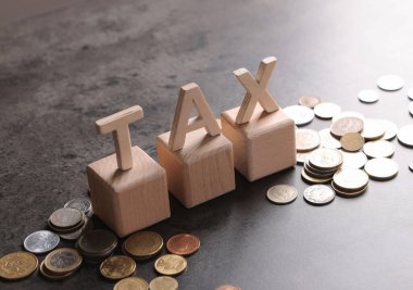 Kelime Vergisi, ahşap harfler ve gri masa üzerinde madeni paralar, metin için boşluk