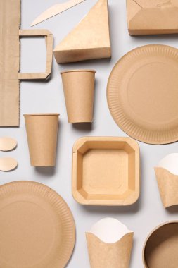 Açık gri arka planda çevre dostu gıda paketleriyle düz kompozisyon