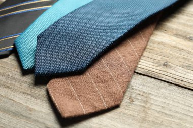 Açık ahşap masada farklı kravatlar, yakın plan.