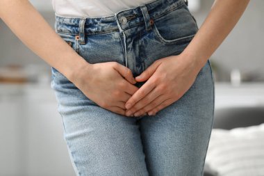 Woman suffering from cystitis at home, closeup