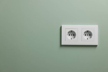 Açık yeşil duvardaki elektrik prizleri kapalı, metin için boşluk