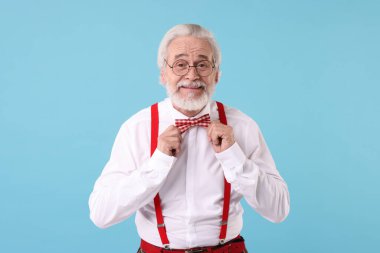 Açık mavi arka planda gözlüklü ve papyonlu şık dedemin portresi.