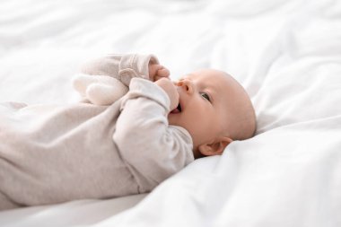 Beyaz çarşafların üzerinde uzanan tatlı bir bebek