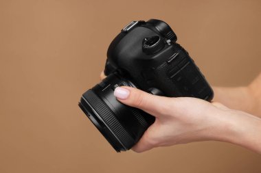 Kahverengi arka planda kamerası olan fotoğrafçı, yakın plan. Metin için boşluk
