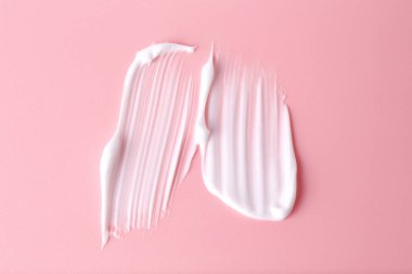 Pembe arka planda vücut bakım kremi örneği, üst görünüm.