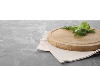 Tahta kesme tahtası, taze fesleğen ve gri masada peçete. Metin için boşluk