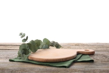 Kesme tahtası, okaliptüs dalı ve tahta masa peçetesi.