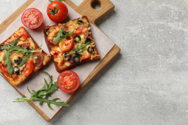 Lezzetli pizza tostları, taze domatesler ve gri masada maydanoz, üst manzara. Metin için boşluk