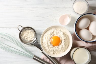 Kasede yumurta sarısı ve hamur için diğer malzemelerle beyaz ahşap masa, düz yatıyordu.