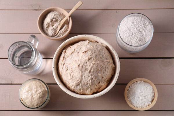 Свежее тесто, мука и вода на деревянном столе, плоский уголок