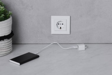 Elektrik prizi ve elektrik bankası beyaz masada.