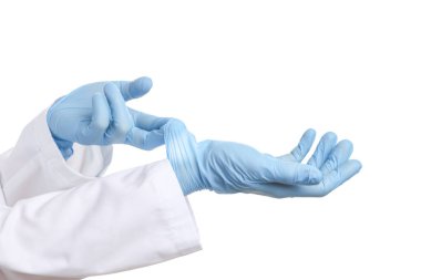 Doktor beyaz arka planda açık mavi tıbbi eldiven giyiyor, yakın plan.