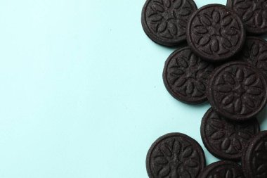 Açık mavi arka planda lezzetli sandviç kurabiyeleri, düz yatış. Metin için boşluk