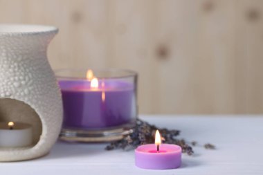 Aromaterapi. Beyaz ahşap masada mum yakmak, yakın çekim. Metin için boşluk