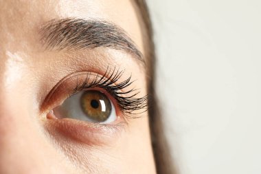 Işıklı arka planda güzel gözlü bir kadının Macro fotoğrafı. Metin için boşluk