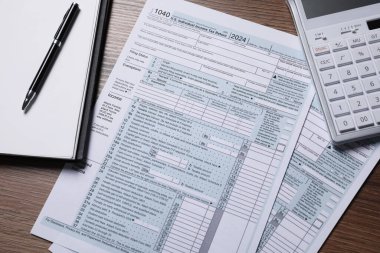 Maaş bordrosu. Vergi iadesi formları, hesap makinesi, defter ve kalem tahtada, düz konum