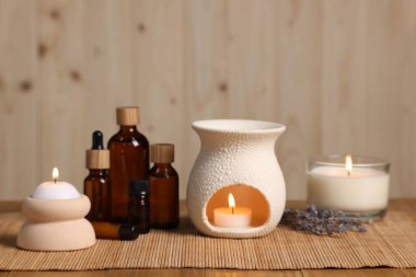 Farklı aromaterapi ürünleri ve masada mum yakmak.