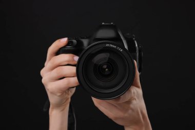 Siyah arkaplanda kamera olan fotoğrafçı, yakın plan