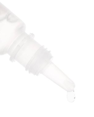 Beyaz arka planda şişeden damlayan tıbbi damlalar