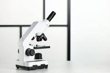 Beyaz tabloda modern mikroskop, metin için boşluk
