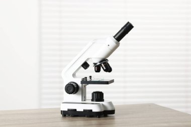 Kapalı alandaki ahşap masada modern tıbbi mikroskop.