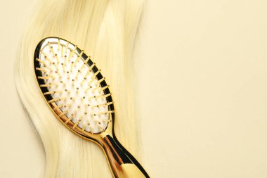 Sarı saç telli, bej arka planda şık fırça, üst manzara. Metin için boşluk