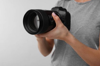 Açık gri arkaplanda kamera olan fotoğrafçı, yakın plan