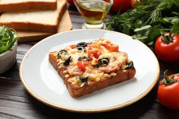 Tasty pizza toast and products on wooden table