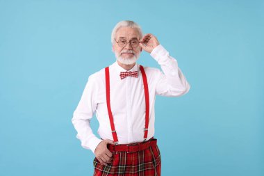 Açık mavi arka planda gözlüklü ve papyonlu şık dedemin portresi.