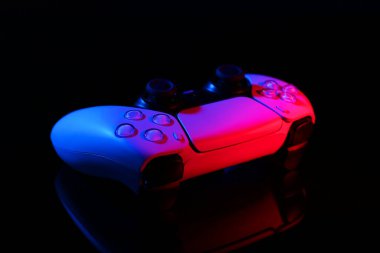 Siyah ayna yüzeyinde neon ışıklarda kablosuz oyun denetleyici