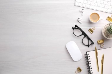 Beyaz ahşap masa üzerinde farklı ofis kırtasiyesine sahip düz kompozisyon, metin için boşluk
