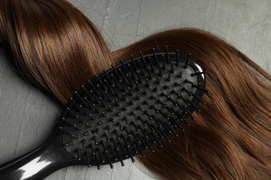 Kahverengi saç telli şık fırça koyu gri masa, üst manzara