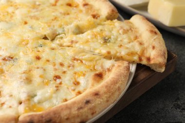 Koyu gri masada nefis peynirli pizza, yakın plan.