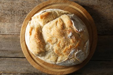 Ahşap masada taze pişmiş ekşi ekmek, üst manzara.