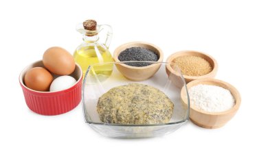 Çiğ hamur ve haşhaş tohumları kasede ve malzemeler beyaza izole edilmiş.