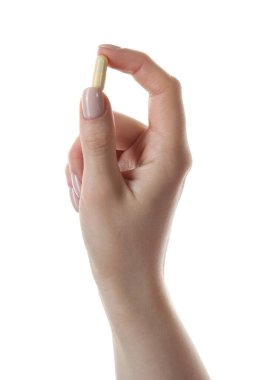 Beyaz arka planda vitamin kapsülü tutan kadın, yakın plan. Sağlık takviyesi