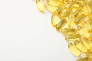 Beyaz arka planda sarı vitamin kapsülleri, üst manzara. Metin için boşluk