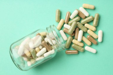 Naneli arka planda vitamin hapları ve şişe, üst görünüm