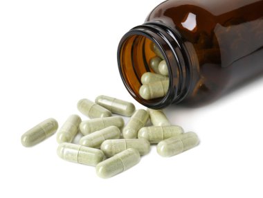 Dağıtılmış vitamin kapsülleri ve beyaz üzerine izole edilmiş şişe.