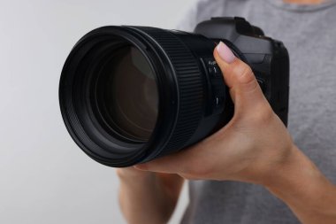 Açık gri arkaplanda kamera olan fotoğrafçı, yakın plan