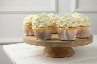 Beyaz ahşap masada kremalı lezzetli vanilyalı kekler.