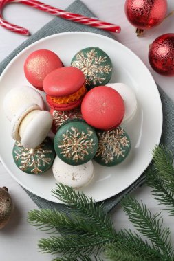 Farklı dekore edilmiş Noel Makaronları ve beyaz ahşap masa üzerindeki şenlikli dekorlar.