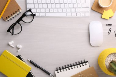 Beyaz ahşap masa üzerinde farklı ofis kırtasiyesine sahip düz kompozisyon, metin için boşluk