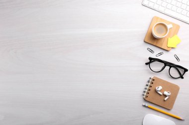 Beyaz ahşap masa üzerinde farklı ofis kırtasiyesine sahip düz kompozisyon, metin için boşluk