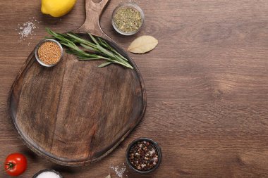 Tahta kesme tahtası, baharatlar, ahşap masada limon ve domates, düz yatak. Metin için boşluk