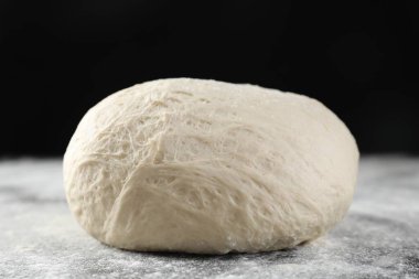 Çiğ hamur ve un siyah masada.