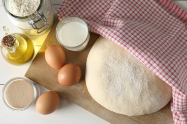 Çiğ hamur ve malzemeler beyaz ahşap masa üzerinde, üst manzara