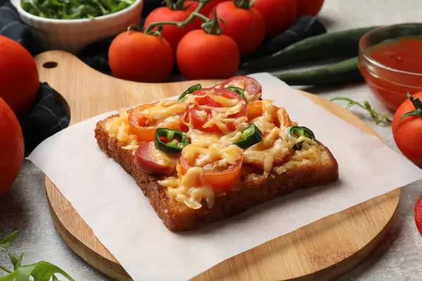 Tasty pizza toast, tomatoes and sauce on grey table, closeup