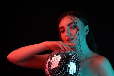 Disko topuyla güzel bir kadın siyah arka planda neon ışıklarda poz veriyor.