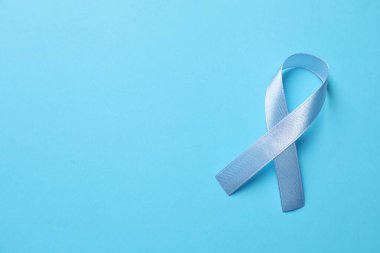 Uluslararası Sedef Günü. Açık mavi arkaplanda desteğin sembolü olarak kurdele, üst görünüm. Metin için boşluk